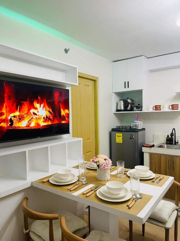 a kitchen with a dining table with a fireplace at Lovely 2 bedroom condo unit in Iloilo City