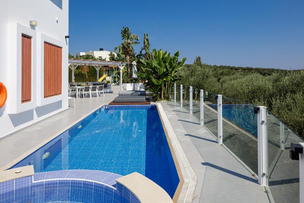 a swimming pool on the side of a house at Chara Sensory Luxury Villa with Heated Pool & Gym, By ThinkVilla in Panormos Rethymno