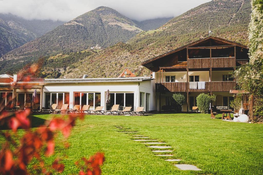 a house with a lawn and mountains in the background at Residence Montani in Laces