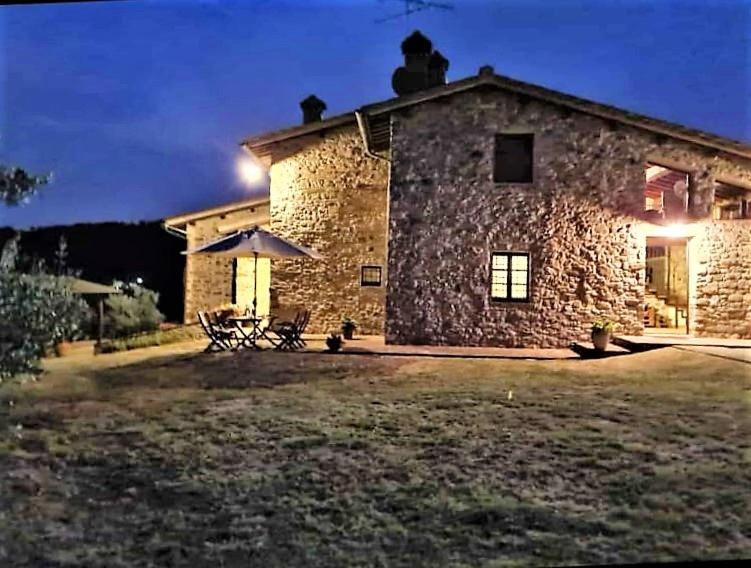 une maison en pierre avec une table et des chaises devant elle dans l'établissement Casa Buriano, à Quarrata