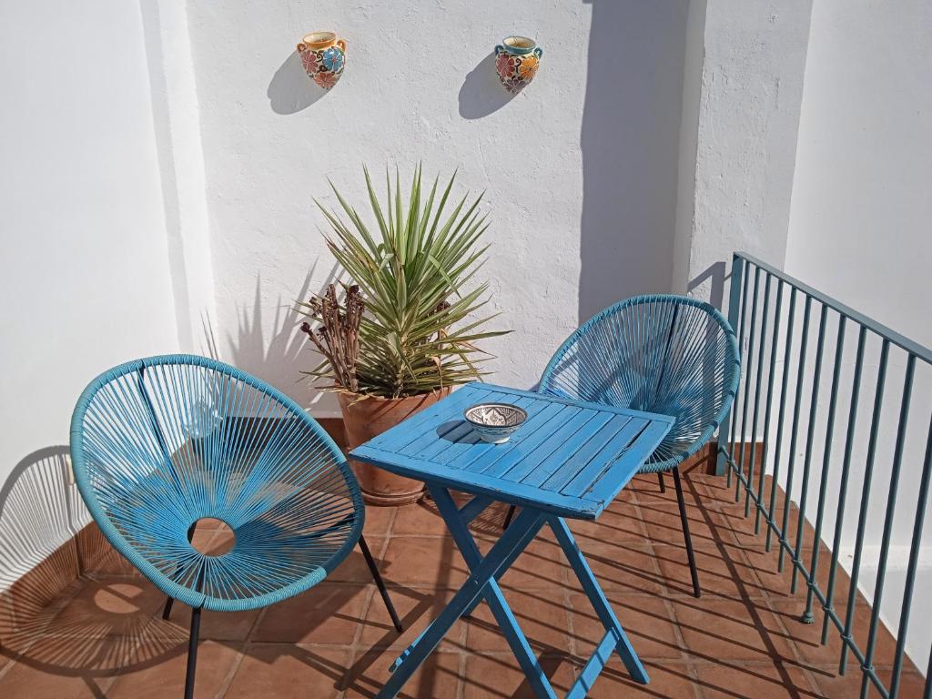 uma mesa azul e duas cadeiras numa varanda em Lake room 2 em Iznájar