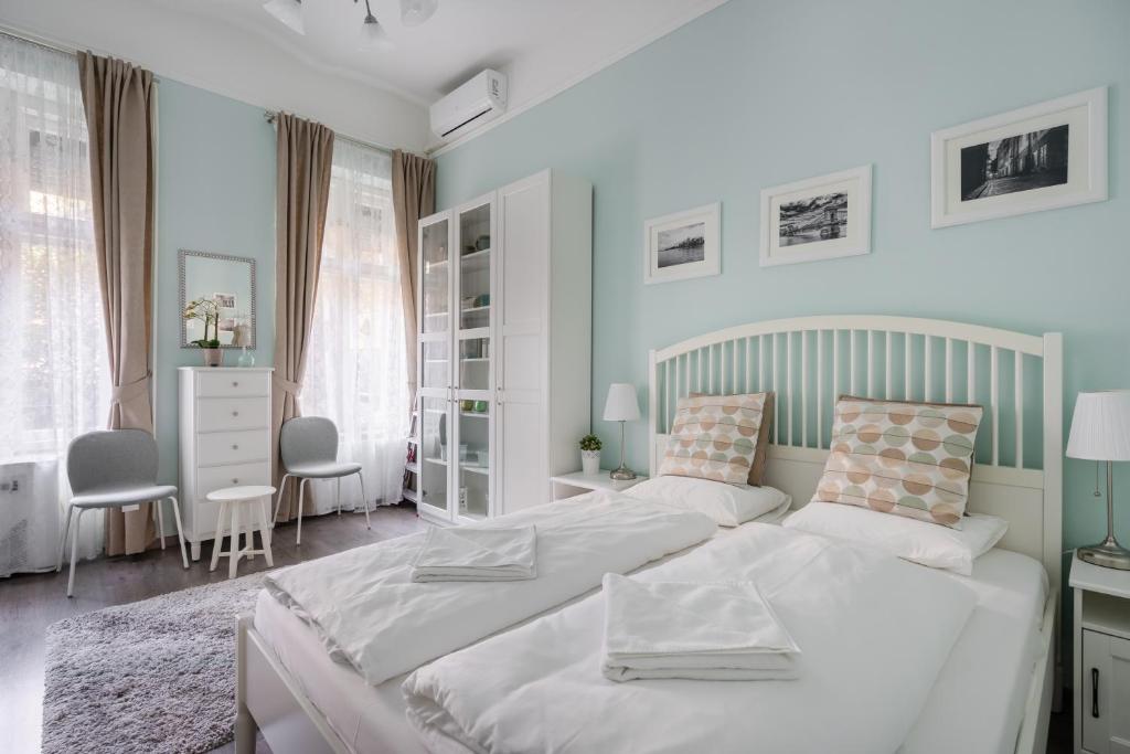 een slaapkamer met 2 bedden en een tafel en stoelen bij Stella Apartment in Boedapest
