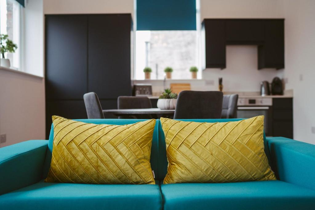 a yellow pillow on a blue couch in a living room at Apartment 8 2 bedrooms, sleeps x 6 in York
