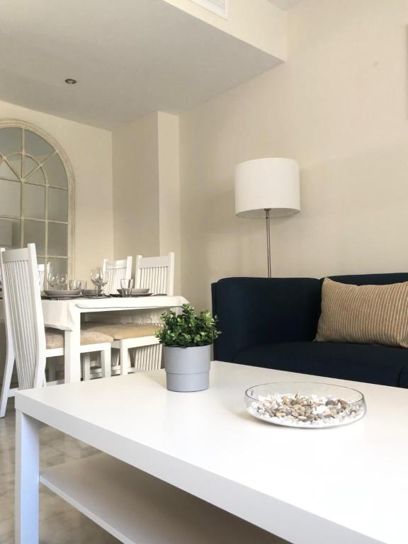 uma sala de estar com uma mesa branca e um sofá em Apartamento Puerta Cerrada em Écija