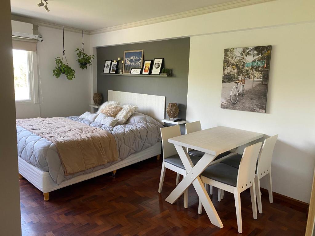 una camera con letto, tavolo e sedie di G3 Inn apartments a Mendoza
