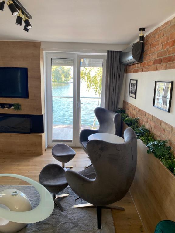 uma sala de estar com duas cadeiras e uma televisão em Apartament MoLoo III em Ostróda