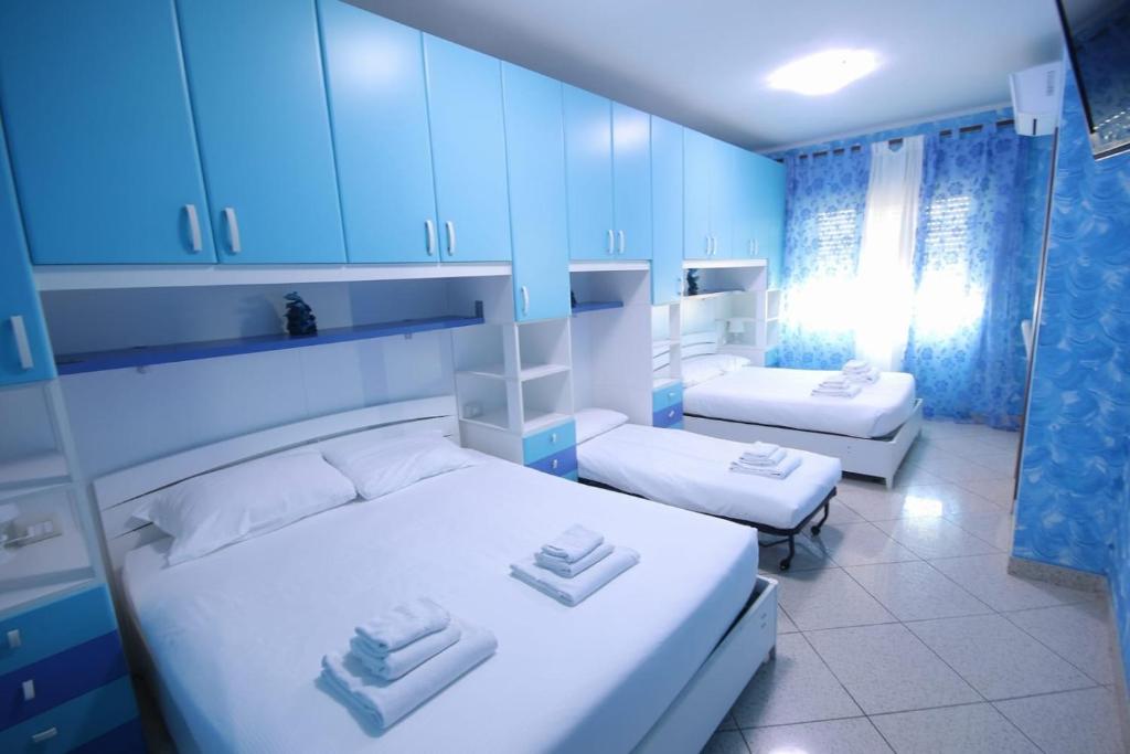 a bedroom with two beds and blue cabinets at Marco Aurelio in Rome