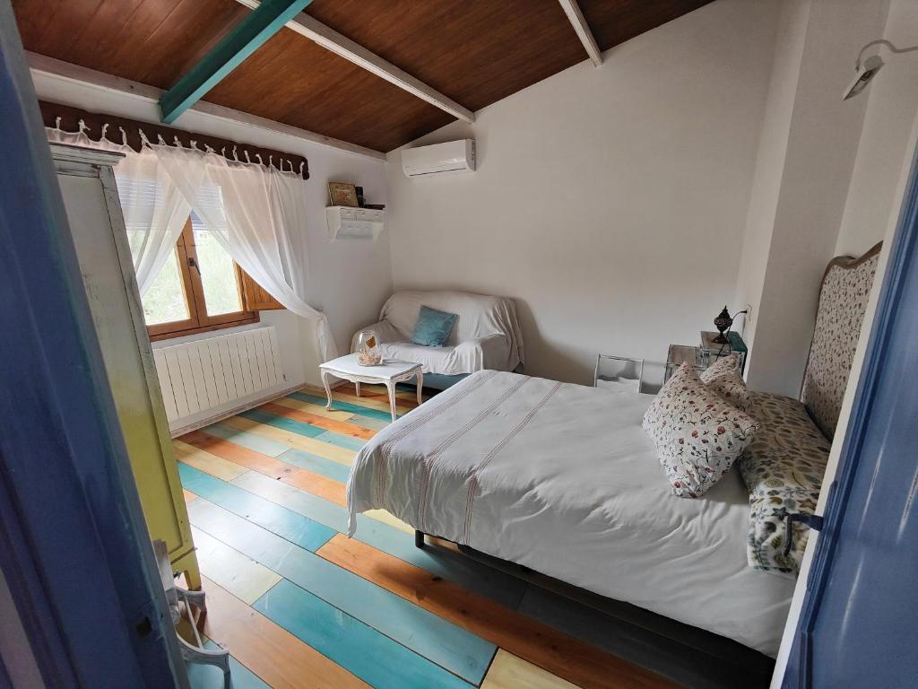 a bedroom with a bed and a couch in it at Vivienda rural del salado in Jaén