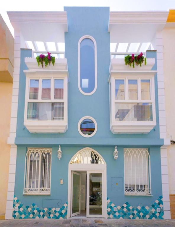 niebiesko-biały budynek z białymi oknami w obiekcie Apartamentos Joya del Mar w mieście Torre del Mar