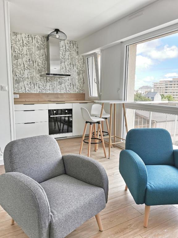 un salon avec deux chaises et un canapé dans l'établissement Appartement lumineux avec balcon et parking, à Cherbourg en Cotentin
