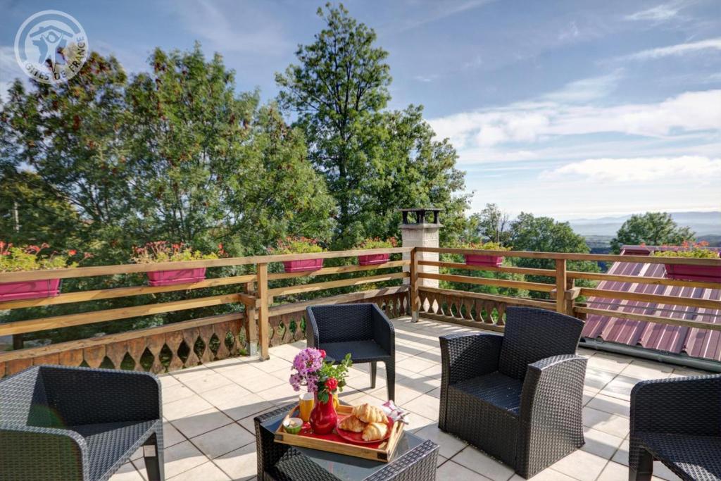 a patio with chairs and a table and a fence at Les blancs moutons in Gumières