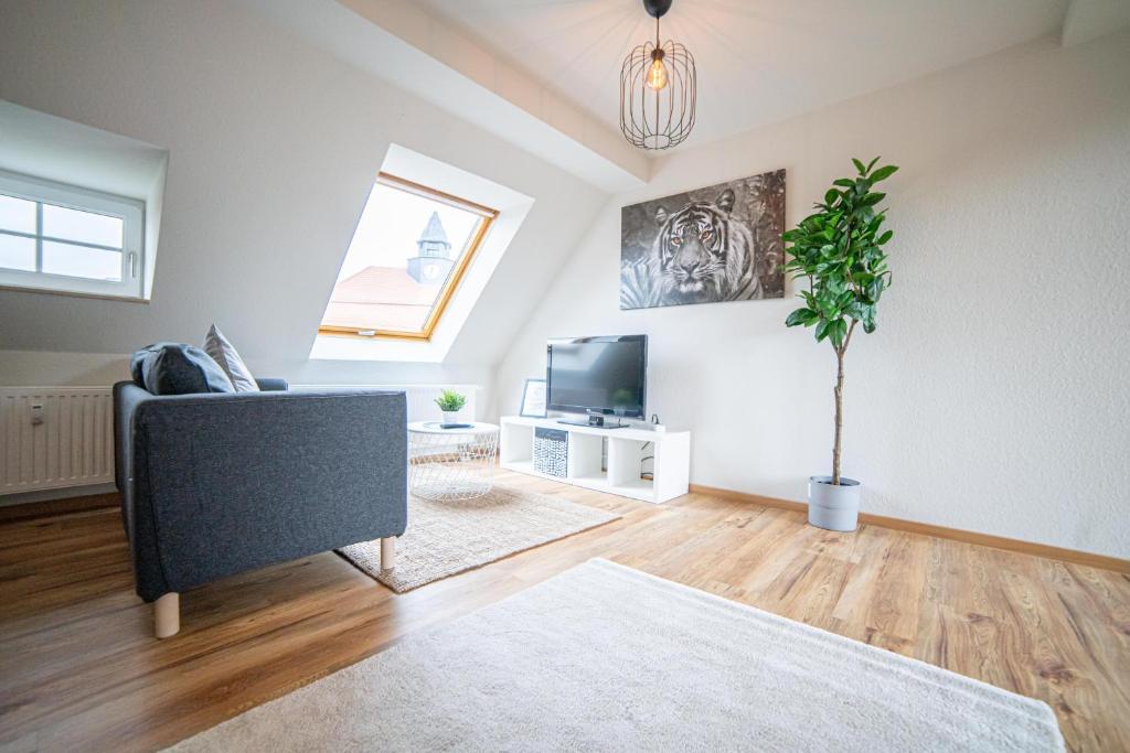 a living room with a couch and a tv at FULL HOUSE Premium Apartments - Zwickau rooftop in Zwickau