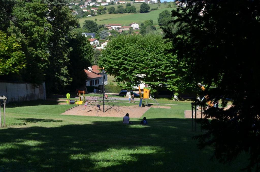 a park with a playground with people in the grass at Le sorberan in Sorbiers