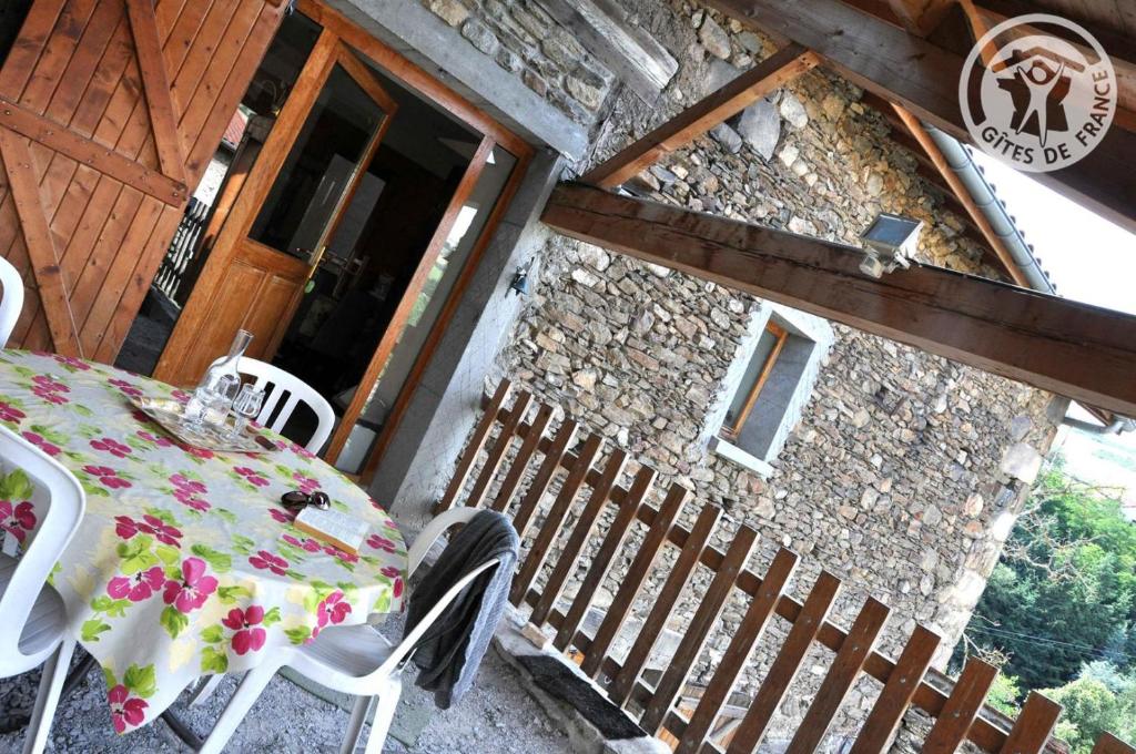 einen Tisch und Stühle auf der Veranda eines Hauses in der Unterkunft Le poulailler in La Terrasse-sur-Dorlay