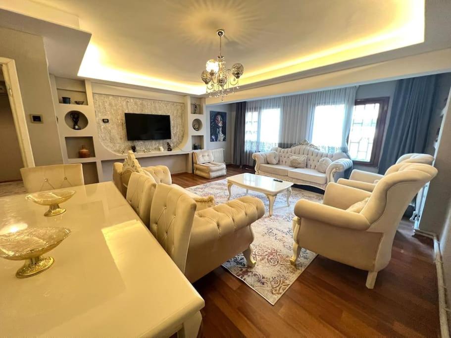 a living room with a table and chairs and a living room at Florya da 3+1 lüx keyifli bahçeli daire in Istanbul