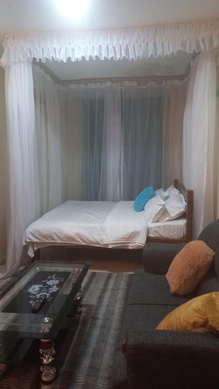 ein Wohnzimmer mit einem Bett und einem Couchtisch in der Unterkunft Woodgreek Studio Apartment 4B27 in Kisii