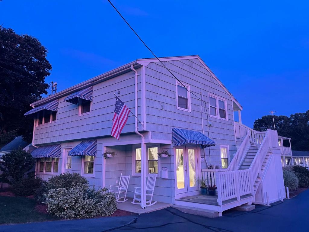 a pink house with an american flag on it at The Escape Inn in South Yarmouth