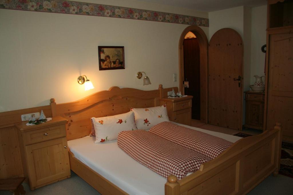 sypialnia z dużym łóżkiem z drewnianym zagłówkiem w obiekcie Apartment Gredler Maria w Mayrhofen
