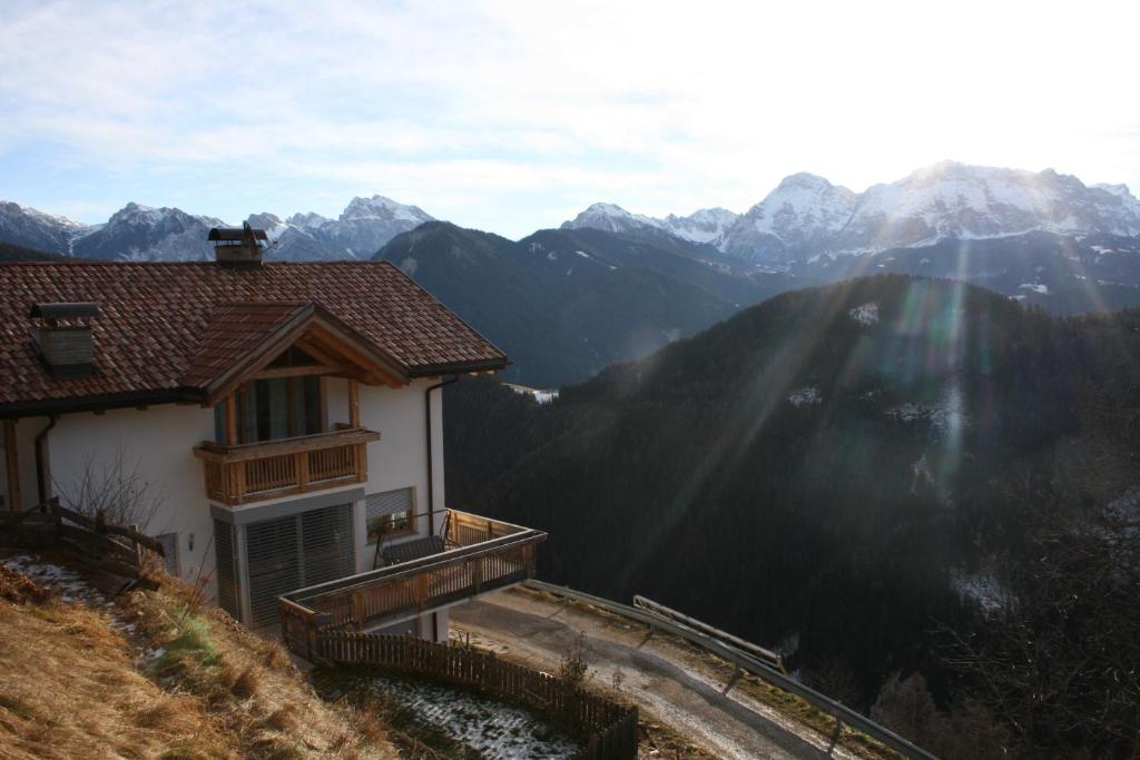 una casa su una collina con montagne sullo sfondo di Lüch da Börz ad Antermoia