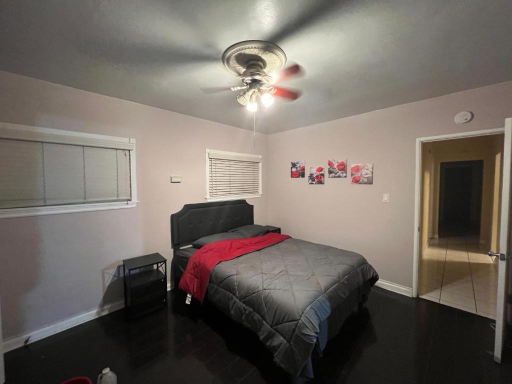 a bedroom with a bed and a ceiling fan at Lucky House in Long Beach