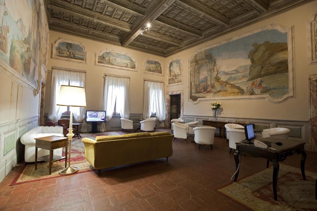 Palazzo Carletti في مونتيبولسيانو: غرفة معيشة مع أريكة وكراسي