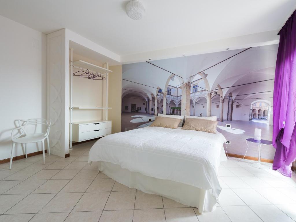 1 dormitorio con cama blanca y pared morada en Alla scoperta delle Marche, en Camerino