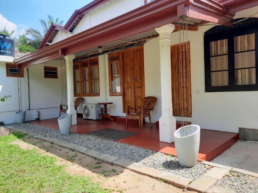 ein Haus mit einer Veranda mit einem Tisch und Stühlen in der Unterkunft 1906 Park View in Anuradhapura