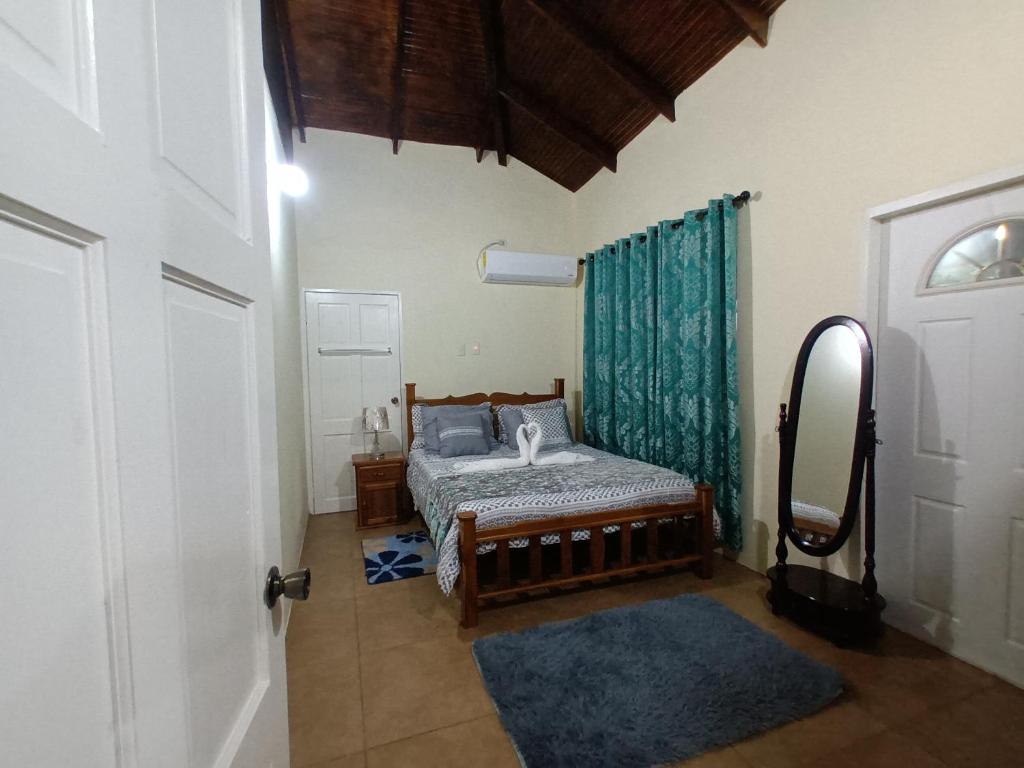 a bedroom with a bed and a door with a mirror at La Casa de Castara in Castara