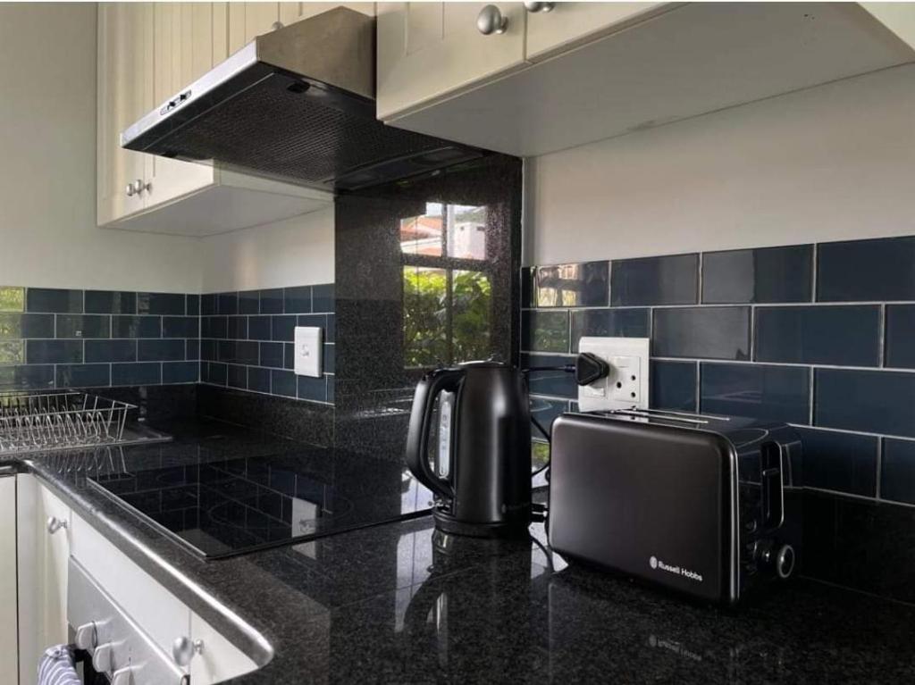 uma cozinha com um balcão preto e comodidades para preparar café em Lux apartment Plett em Plettenberg Bay