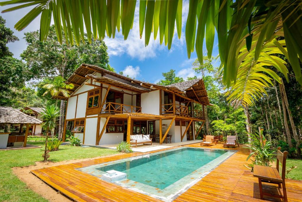 una casa con piscina frente a ella en Village Boutique La Dolce Vita en Trancoso