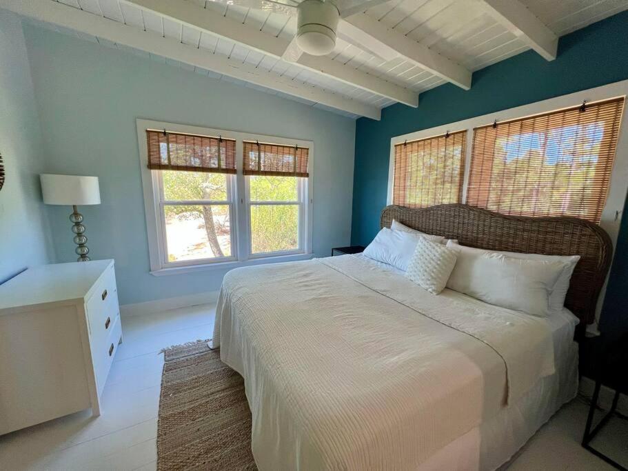 a bedroom with a large bed and two windows at Write on the Bay, a Waterfront Retreat in Coastal Alabama in Fairhope