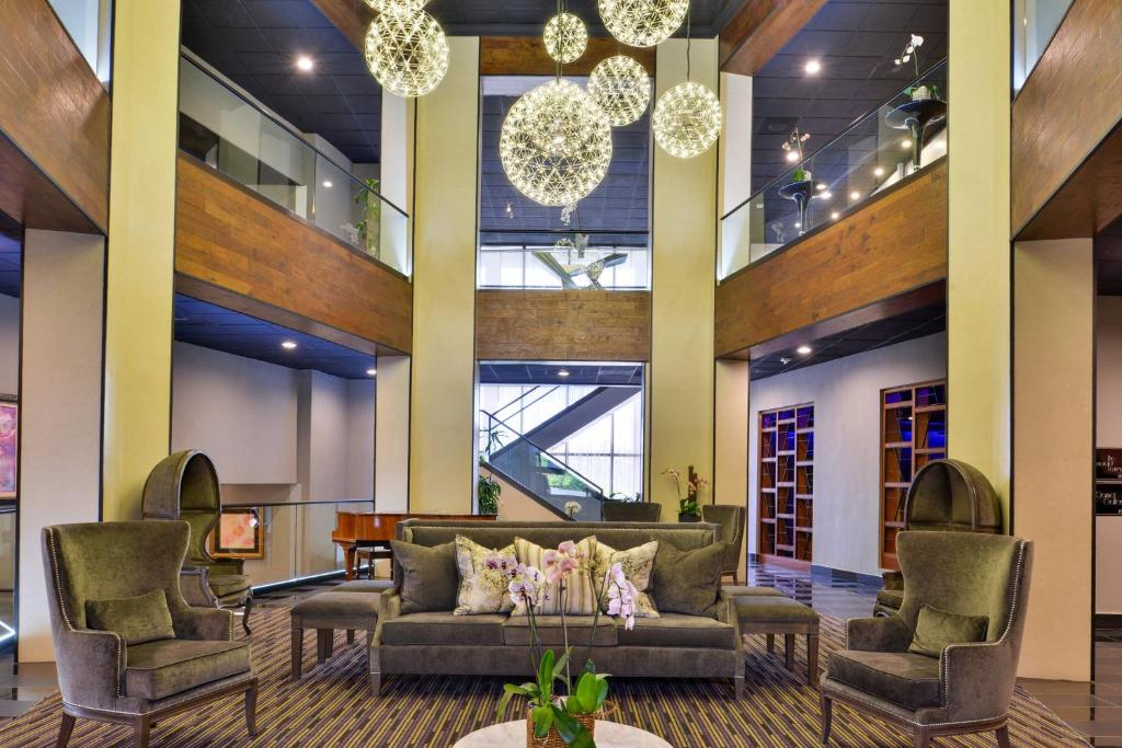 eine Lobby mit einem Sofa, Stühlen und Kronleuchtern in der Unterkunft The Hills Hotel, an IHG Hotel in Laguna Hills