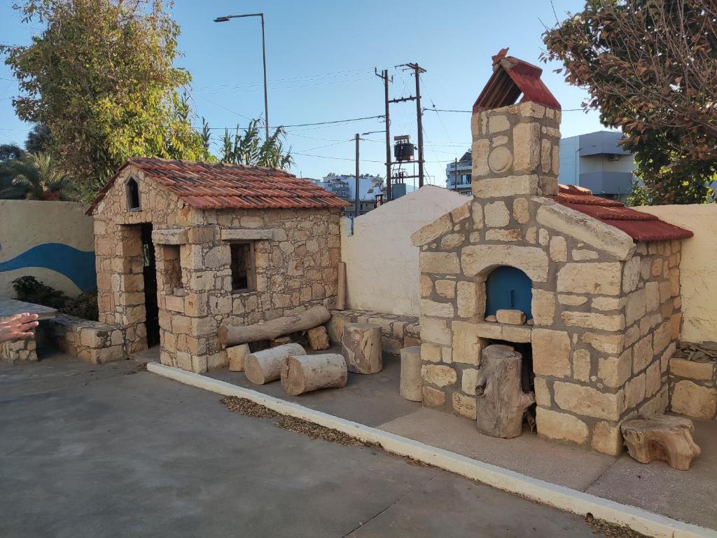 a building with a tower and a small building with a stove at Hotel Tsagarakis Beach in Amoudara Herakliou
