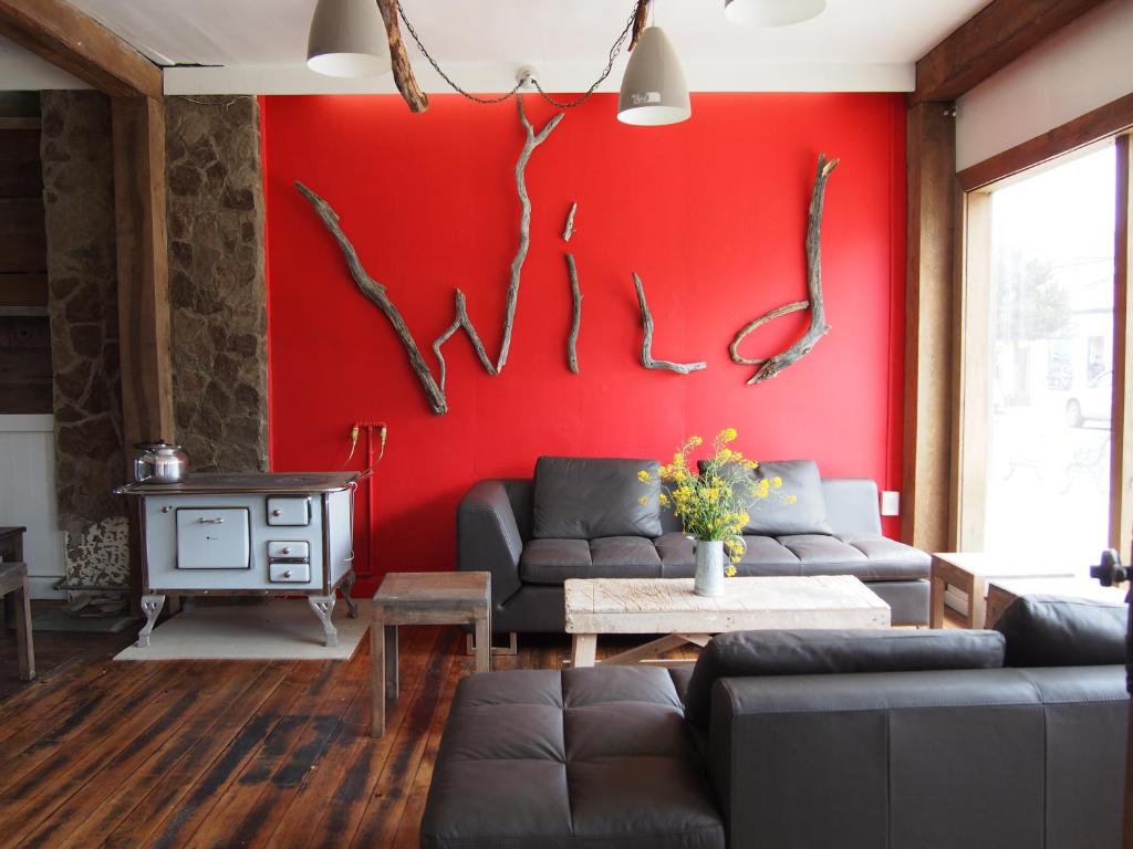 uma sala de estar com uma parede vermelha com chifres em Wild Hostel em Puerto Natales