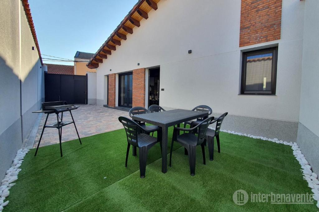 a patio with a table and chairs on grass at Casa galana 