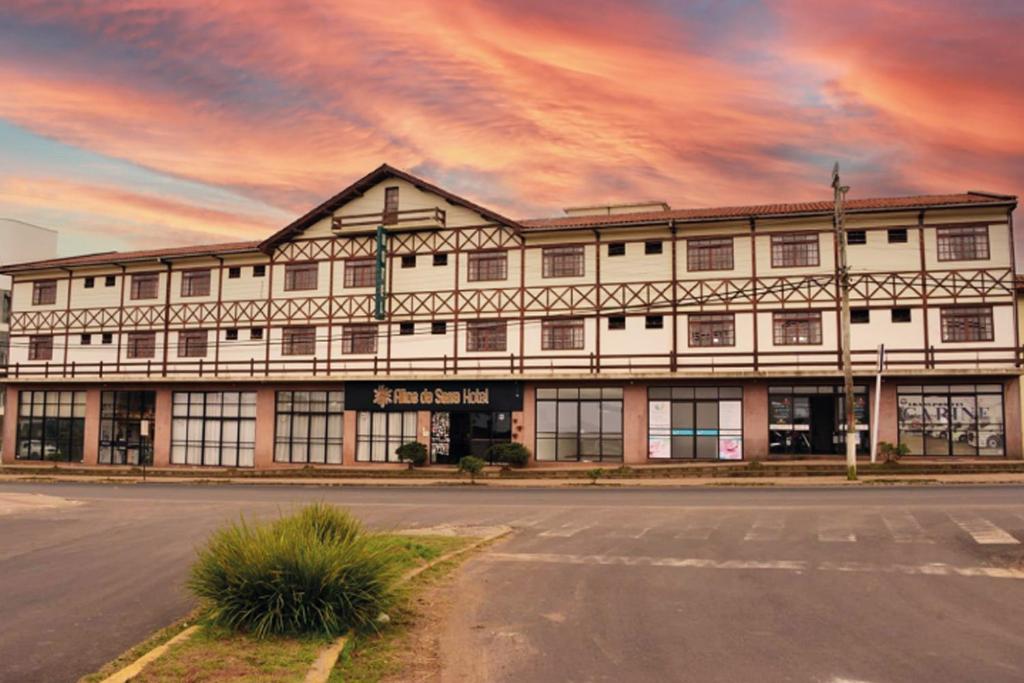 een groot wit gebouw met een straat ervoor bij Altos da Serra Hotel in São Joaquim