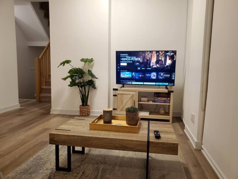 - un salon avec une télévision et une table basse dans l'établissement Midtown 4 bedroom home Free Wi-Fi and parking, à Toronto