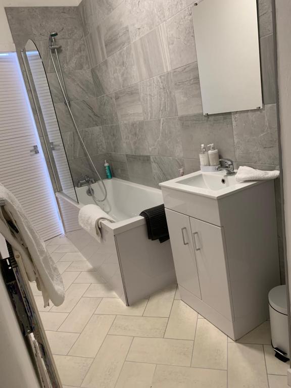 a bathroom with a tub and a sink and a shower at clyde hub in Gourock