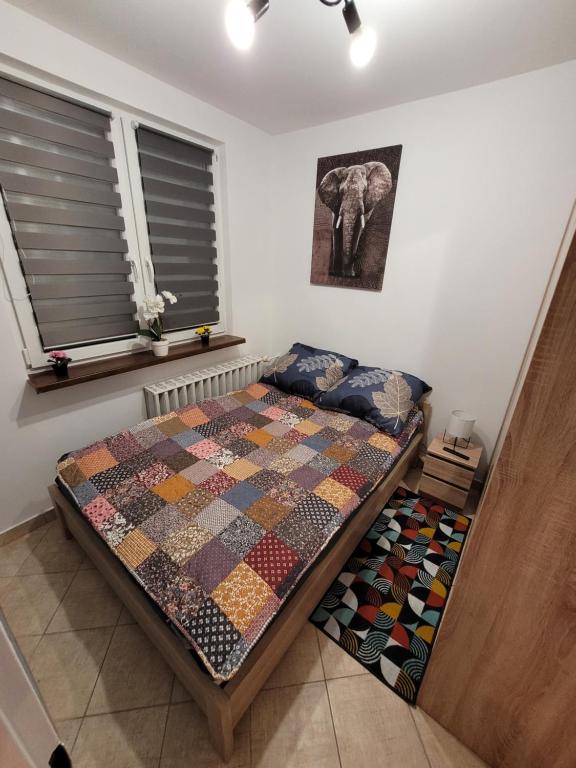 a bedroom with a bed with a quilt on it at Apartament Leon in Wałbrzych