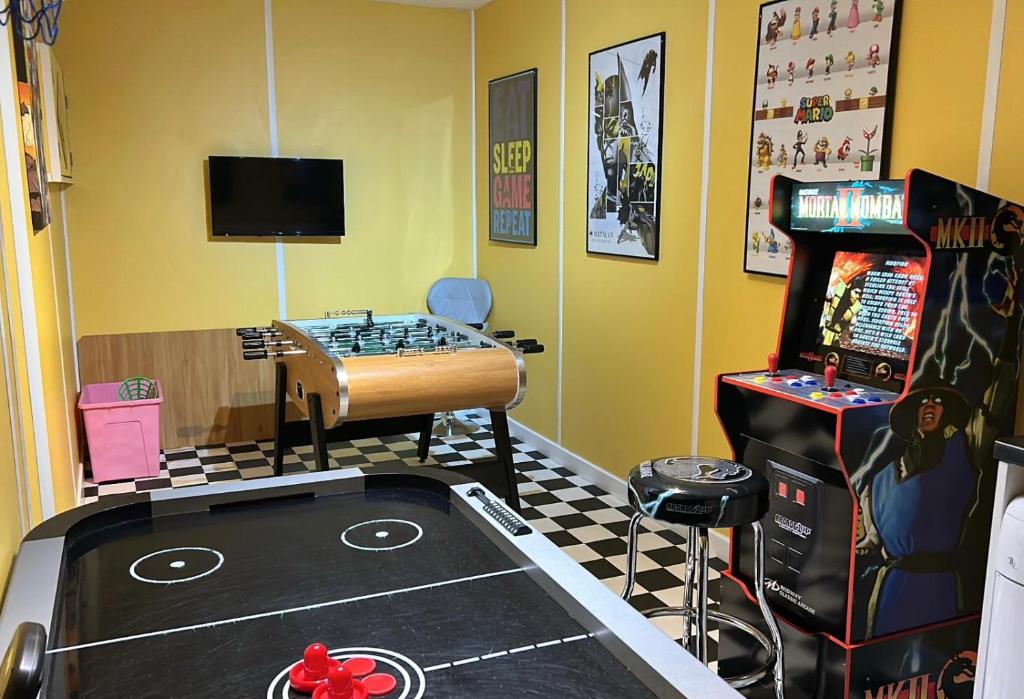 a room with a video game room with a bed and a pinball machine at Seapoint House in Cleveleys