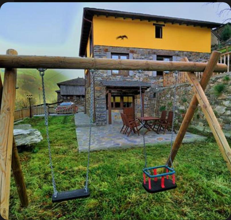 a house with a yard with swings in front of it at Casa Corral - Casas de Aldea in Monón