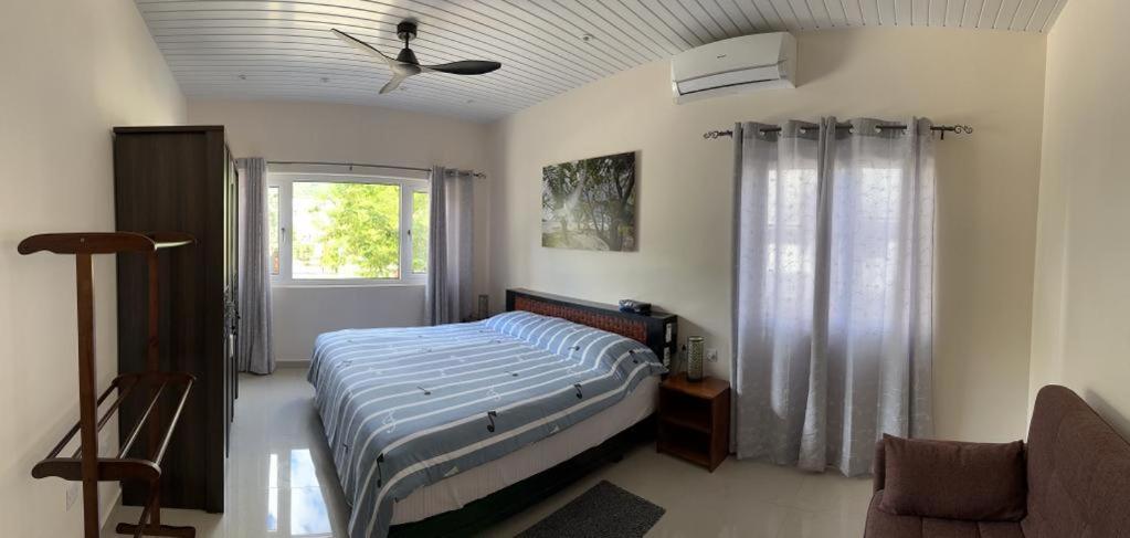 a bedroom with a bed and a ceiling fan at Coco De Mer Villa in Mahe
