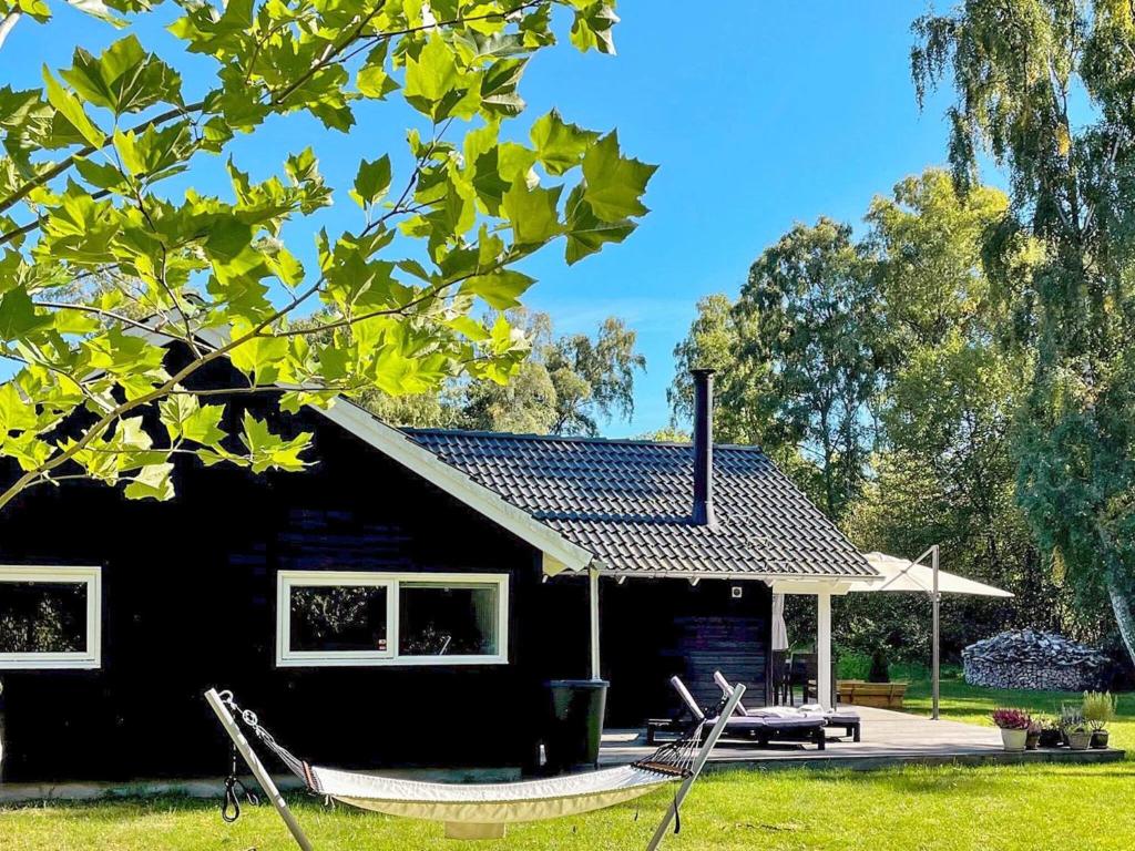 una cabaña negra con mesa de picnic y mesa de picnic en Holiday home Frederiksværk XXIV, en Frederiksværk