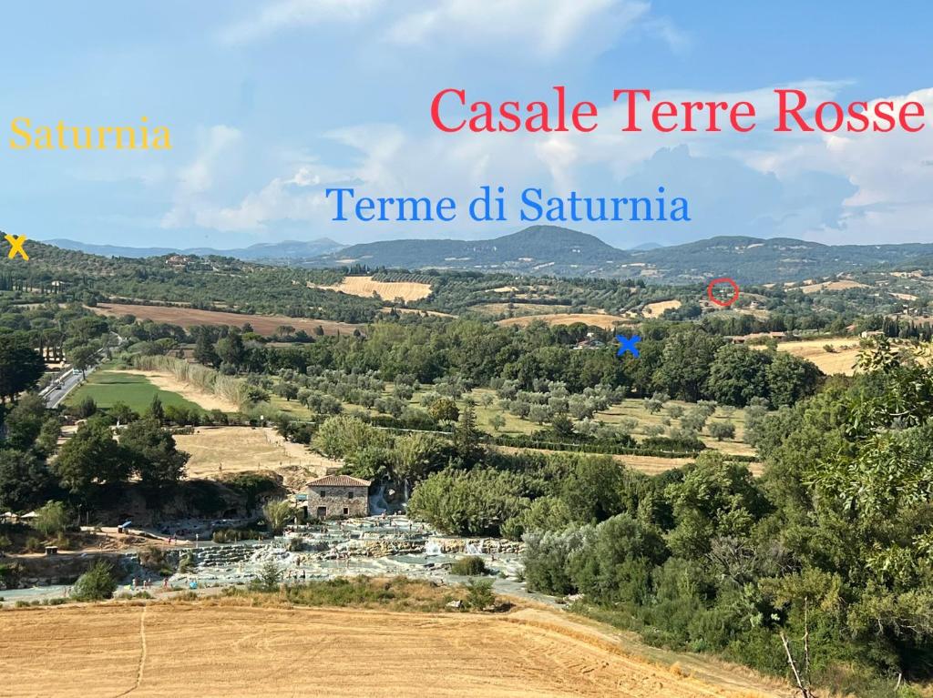 a view of a valley with trees and a town at Casale Terre Rosse in Saturnia