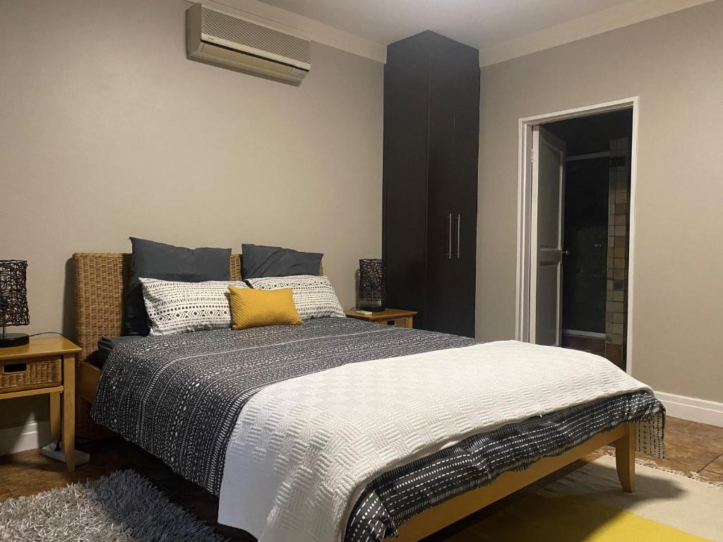 um quarto com uma cama com almofadas amarelas em The Cottage em Somerset West