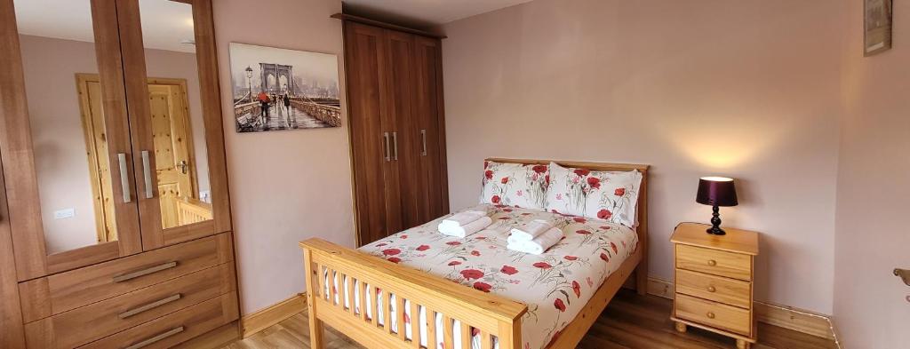 a small bedroom with a bed and a wooden cabinet at Reed Warbler Cottage in Ballinrobe