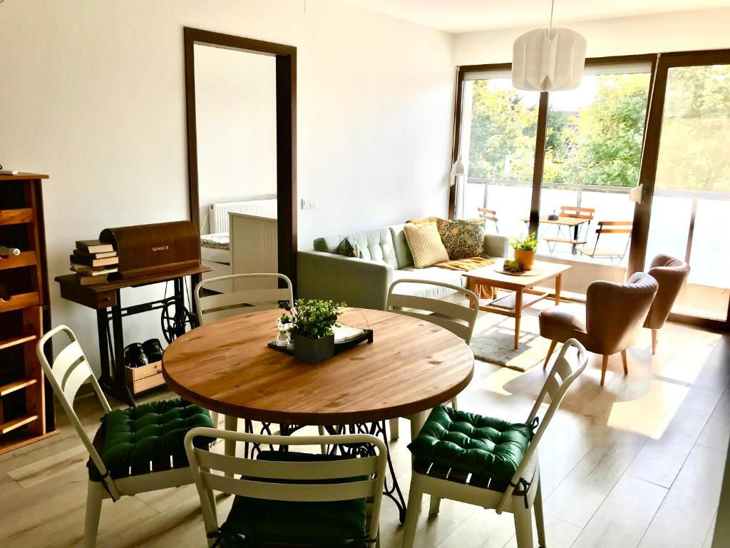 Erkel 19 Apartmanház في كيزتيلي: غرفة معيشة مع طاولة وكراسي