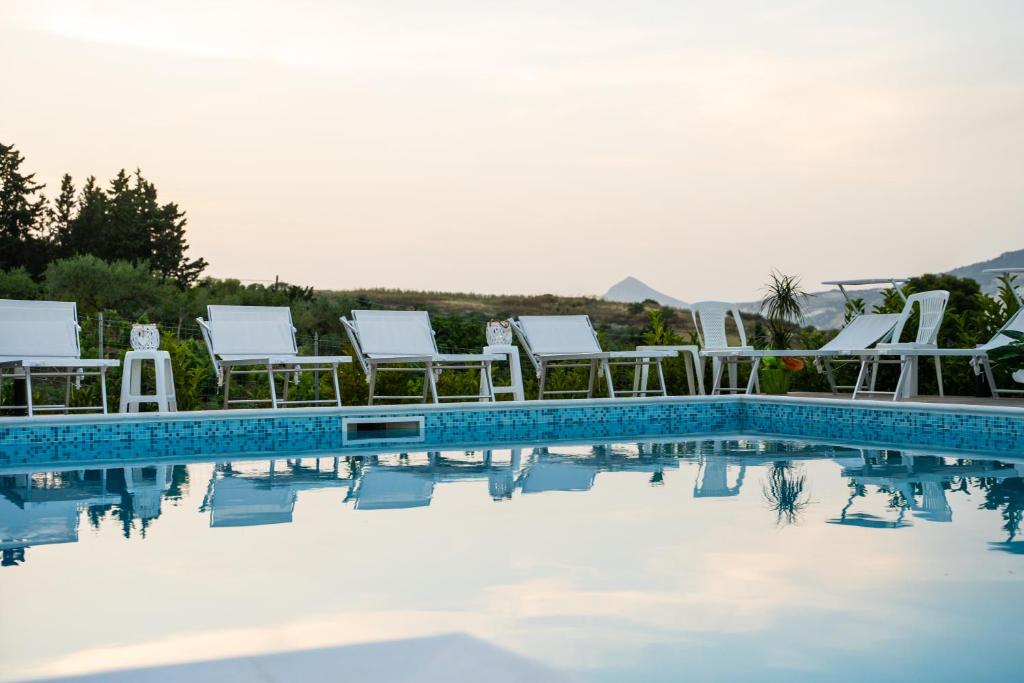 un grupo de sillas y una piscina en Villa Pollina, en Buseto Palizzolo