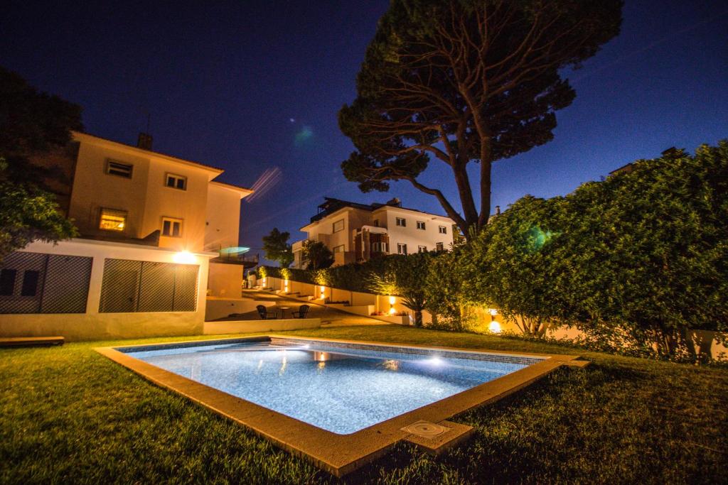 a swimming pool in the yard of a house at night at 188 Apartments - Estrelícia - pool and balcony in Cascais
