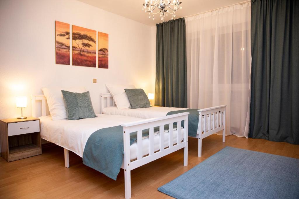 1 dormitorio con 2 camas y lámpara de araña en Große Wohnung, 100 qm mit Terrasse en Alzenau in Unterfranken